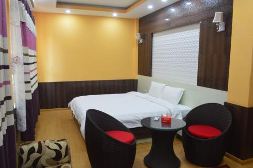 a hotel room with a bed and chairs and a table at Hotel Gorkha Palace Pvt. Ltd in Gorkhā