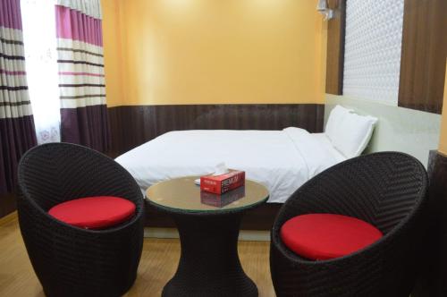 a hotel room with two chairs and a bed at Hotel Gorkha Palace Pvt. Ltd in Gorkhā