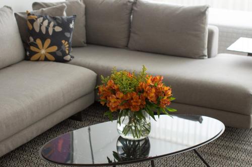a living room with a couch and a vase with flowers on a table at Brasil Suites Boutique Hotel in Athens