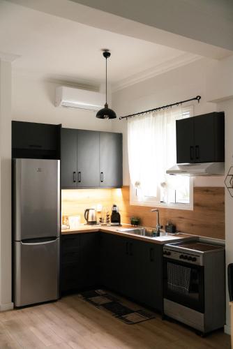 a kitchen with black cabinets and a stainless steel refrigerator at Seaside Casa in Nafpaktos