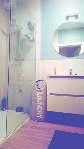 a bathroom with a shower and a sink and a mirror at Apartament przy rzece in Słupsk