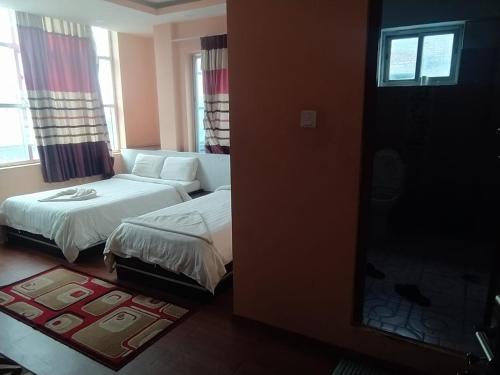 a bedroom with a bed and a couch and a window at Hotel Gorkha Palace Pvt. Ltd in Gorkhā