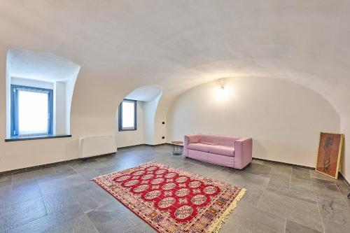 a living room with a pink chair and a rug at Villa Adriana in Lierna