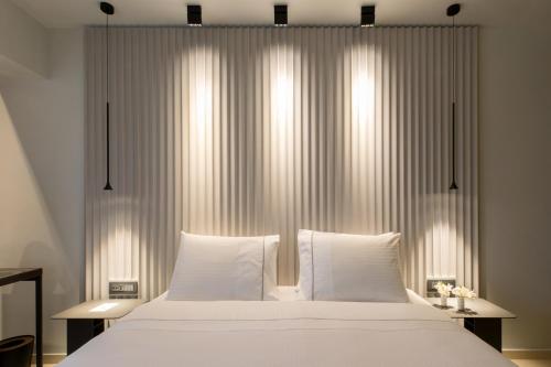 a bedroom with a large white bed with white pillows at Brasil Suites Boutique Hotel in Athens