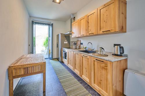a kitchen with wooden cabinets and a wooden table at Villa Adriana in Lierna