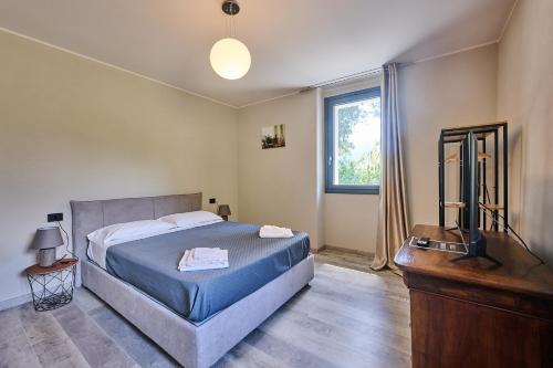 a bedroom with a bed and a television in it at Villa Adriana in Lierna