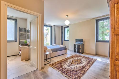 a bedroom with a bed and a tv and windows at Villa Adriana in Lierna