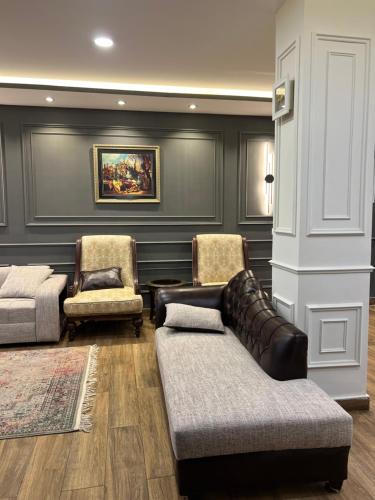 a living room with a couch and two chairs at Blue sky Apartment in Nathia Gali