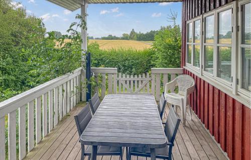 a porch with a wooden table and chairs on a house at 1 Bedroom Lovely Home In Nørre Alslev in Nørre Alslev