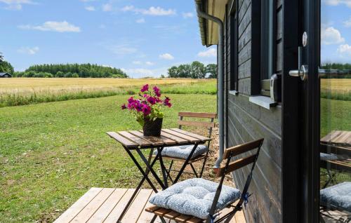 una mesa y sillas en un porche con flores en 3 Bedroom Stunning Home In Stege, en Stege