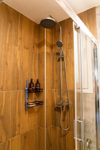 a shower in a bathroom with wooden walls at Seaside Casa in Nafpaktos