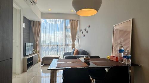 a living room with a dining table and a living room with a couch at Panoramic KL View @Robertson Bukit Bintang 40f in Kuala Lumpur