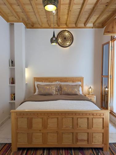 a bedroom with a bed with a wooden dresser at Riad Al Manara in Essaouira