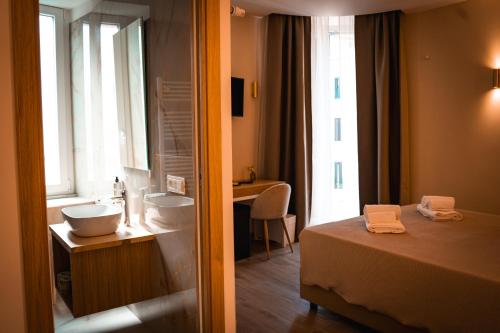 un bagno con un letto, un lavandino e uno specchio di Alma Guest House a Roma