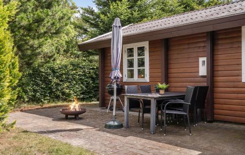 a patio with a table and an umbrella and a fire pit at Nice Home In Tarm With Swimming Pool in Tarm
