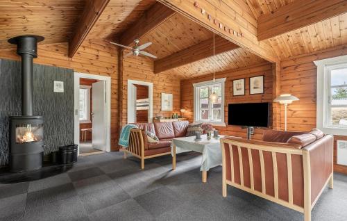 a living room with a fireplace in a wooden house at Nice Home In Tarm With Swimming Pool in Tarm