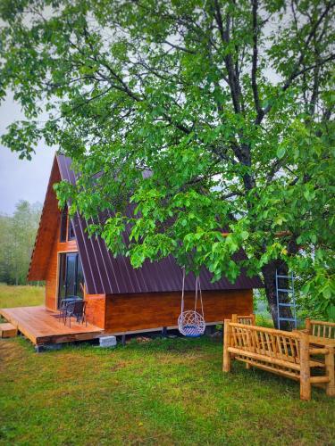 a tiny house with a porch and a swing at Svanieri Cozy Cottage in the Mountains in Katskhi