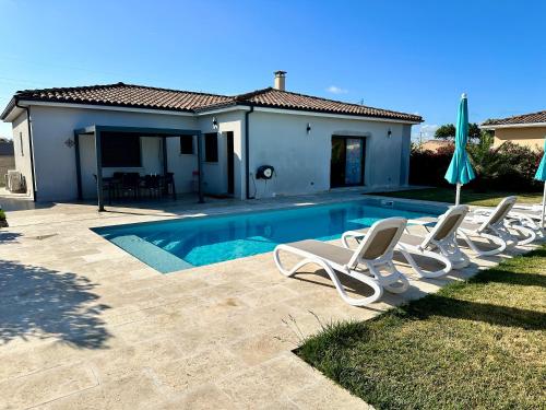 a swimming pool with lounge chairs and a house at Chambre agréable, SDB privée, Clim, Vue Piscine, in Muret