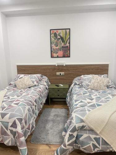 two beds sitting next to each other in a bedroom at Hostal Jimena restaurante el Porvenir in Martiherrero