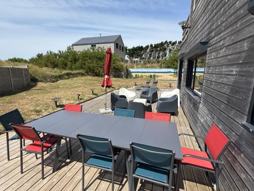 a patio with a table and chairs on a deck at Beach House in Port-Bail-sur-Mer