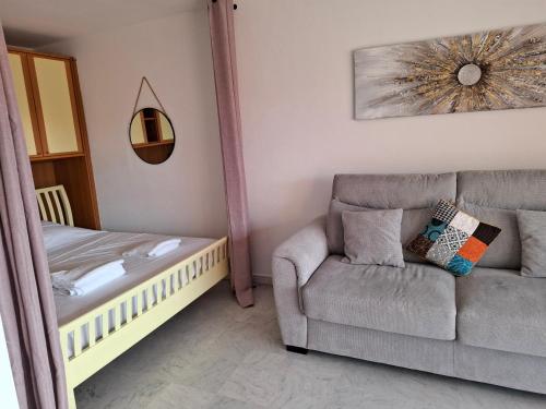a living room with a couch and a chair at Appartement exposé plein sud in Menton