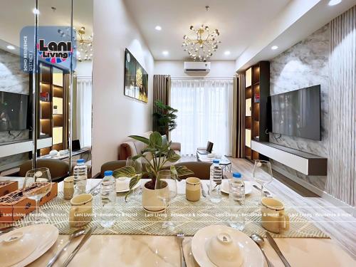 ein Esszimmer mit einem Tisch mit Tellern und Gläsern in der Unterkunft Lani Living - Residence & Hotel in District 1 in Ho-Chi-Minh-Stadt