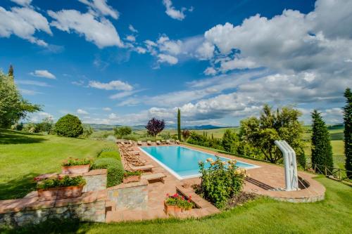 an outdoor swimming pool with a patio and a yard at Agriturismo Poggio Istiano in Bagno Vignoni