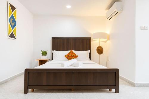 a bedroom with a large bed with white sheets and pillows at Urban One Luxury Apartments, Kumasi - Gye Nyame in Kumasi