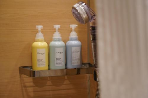 three bottles of detergent sitting on a shelf in a bathroom at Hotel Great Morning in Fukuoka