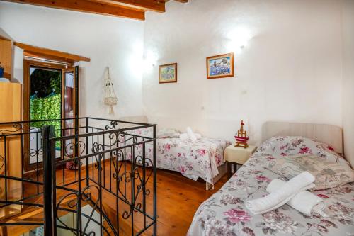 una camera da letto con due letti e un balcone di Villa Sofita with jacuzzi a Maroulás