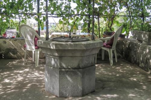 Una mesa de piedra y sillas bajo un árbol. en apartman kostrena, en Kostrena