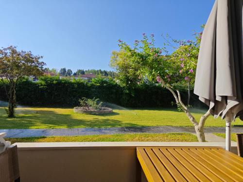 a wooden bench with an umbrella and a garden at Sun And Roses Siviri in Siviri