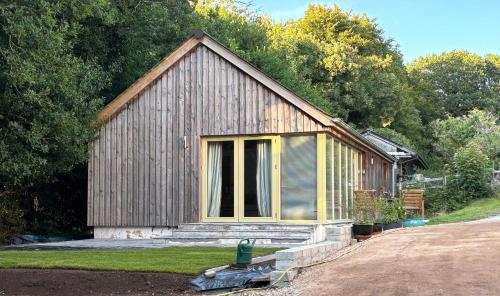 a small wooden building with a window on the side at Oak Lodge in Tavistock