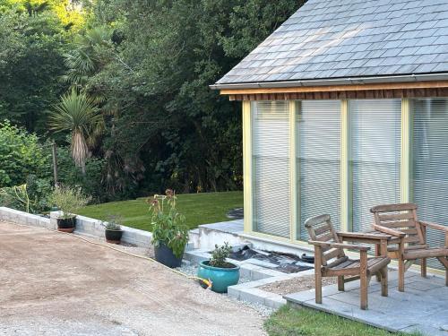 two chairs and a table in front of a gazebo at Oak Lodge in Tavistock