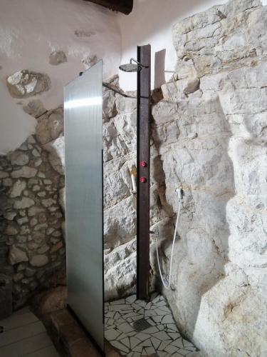 a bathroom with a stone wall with a shower at #3MTSOPRAILCIELO '' SCuLPTuRe '' in Felitto