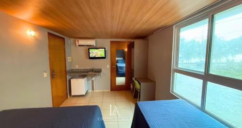 a bedroom with a bed and a large window at LA Green Sunset in João Pessoa