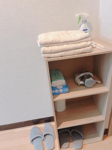 a shelf with towels and shoes in a room at ひまわりHotel in Nagasaki