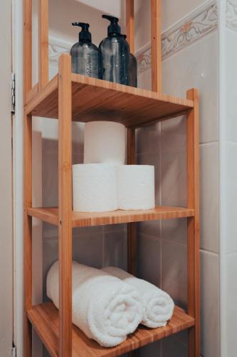 a wooden shelf with towels and toiletries in a bathroom at Central Manchester Gem with Stylish 2BR Retreat and Free Carpark in Manchester