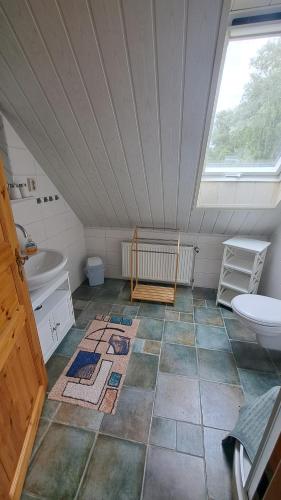 a attic bathroom with a sink and a toilet at Ferienhaus Neela in Plau am See
