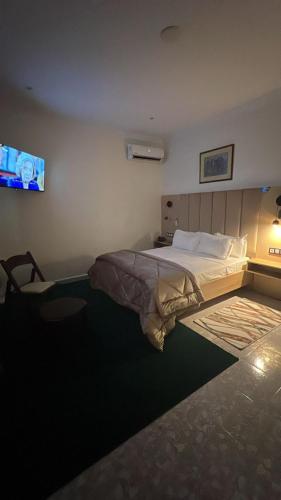 a bedroom with a bed and a tv on the wall at Hotel MEDINA in Oran