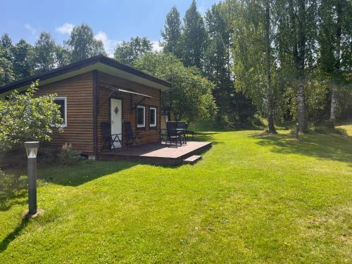a small cabin with a deck in a yard at Katase Tiny House in Katase