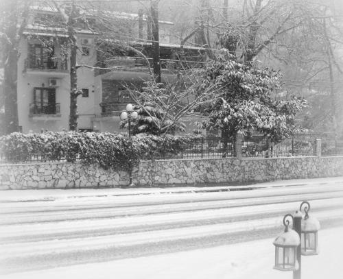 a snowy street with two lights in front of a building at Nostos Hotel in Kato Loutraki