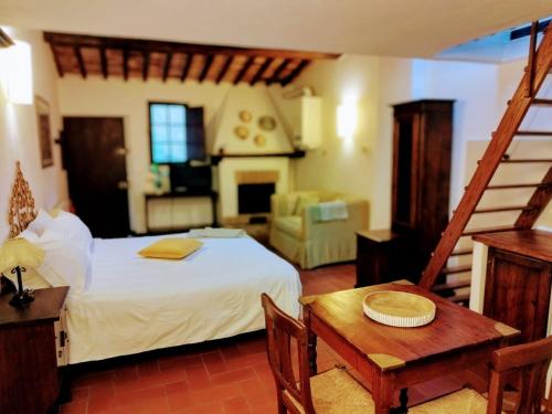 a bedroom with a bed and a table and a chair at L'orto Delle Terme in Bagno Vignoni
