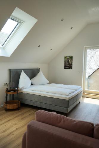 a bedroom with a bed and a couch at Hain Estate Appartements in Piesport
