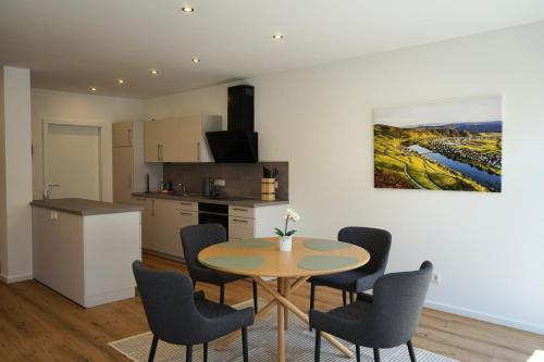 Una cocina y un comedor con mesa y sillas. en Hain Estate Appartements, en Piesport