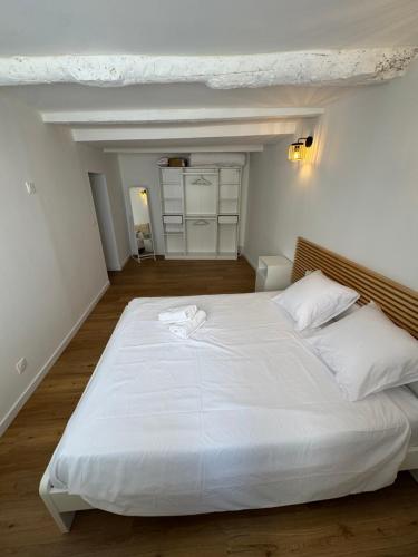 a large white bed with two white towels on it at Marceau II - Une pépite dans le cœur de ville in Aubagne