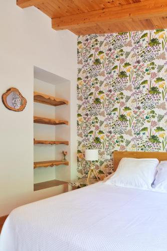 a bedroom with a white bed and a floral wallpaper at La Casa de Los Moyas in Olba