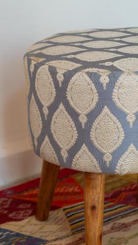 a wooden stool with a blue and white pattern on it at Riad Al Manara in Essaouira