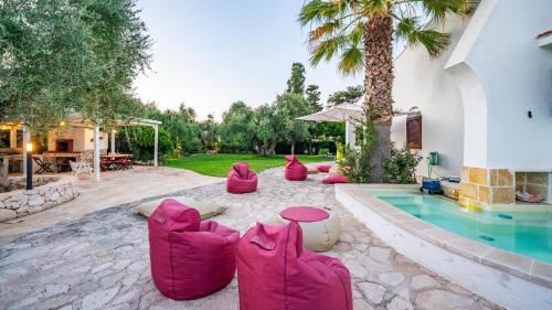 a group of pink bean bags sitting next to a pool at Villa Giglio with Garden and Mini Pool by Rentbeat in Rosa Marina