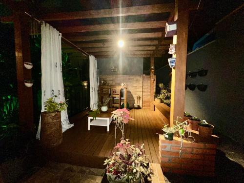 a porch with potted plants and a table and a light at Arthi - LINDO LOFT RECANTO DOS PASSARINHOS com HIDROMASSAGEM! in Balneário Camboriú